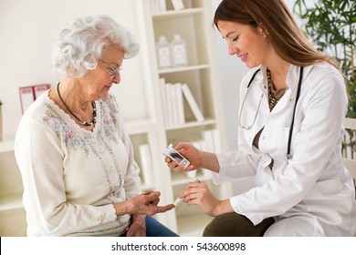 Young Female Doctor Making Diabetes Blood Test On Senior Woman, Closeup