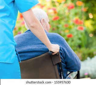 Young female doctor pushing and old patient in wheelchair. - Powered by Shutterstock