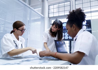 Young Female Doctor Student Internship Team Group Meeting And Discussing About Brain Cancer Surgery Treatment Patient Case At The Lab Office In Hospital. Healthcare And Medical Education Concept.