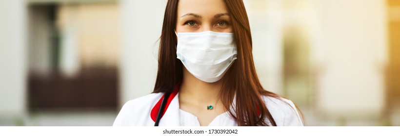 Young Female Doctor In Surgical Mask And Earbuds Outdoors Banner