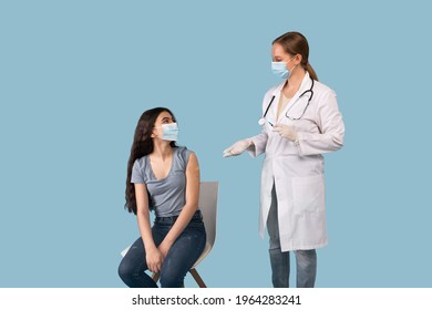 Young Female Doctor Talking To Teen Patient After Giving Her Shot Of Coronavirus Vaccine Over Blue Studio Background. Protection Against Covid-19, Immunization Campaign Concept