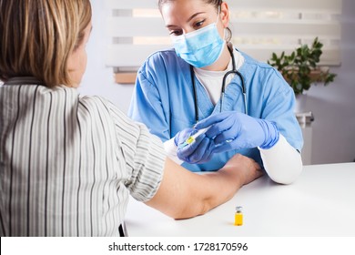 Young Female Doctor Vaccinating Elderly Patient In UK GP's Office,virus Disease Therapy And Treatment,remedy And Cure For Infections Or Seasonal Flu,Coronavirus COVID-19 Potential Vaccine Development