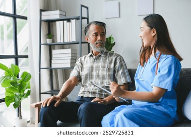 Young female doctor is visiting a senior male patient and taking notes on a clipboard in a home healthcare setting - Powered by Shutterstock