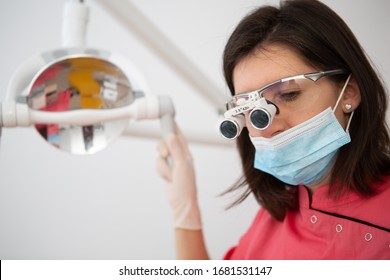 Young Female Doctor Wearing Dental Loupe Binoculars, Headshot Portrait At Work Process