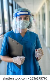 Young female doctor wearing face shield holding  test tube with a blood sample with a positive result  Covid-19 