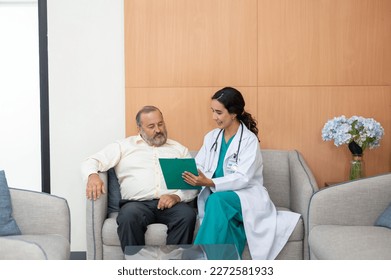 Young female doctor in white medical gown showing medical test result explaining prescription using clipboard senior man patient sitting on sofa in the hospital corridor - Powered by Shutterstock