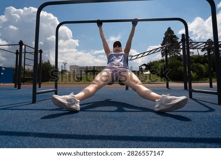 a a young female does pull-ups on a crossbar, fitness classes for weight loss