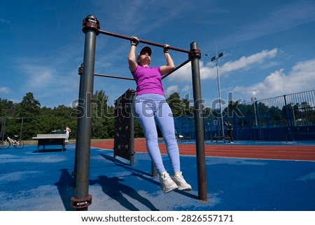 a young female does pull-ups on a crossbar, fitness classes for weight loss