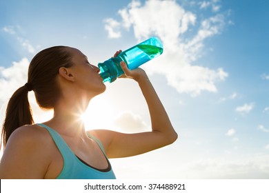 Young female drinking a bottle of water. 