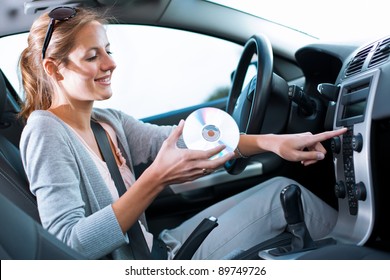 Young Female Driver Playing Music In The Car (changing CDs)