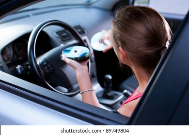 Young Female Driver Playing Music In The Car (changing CDs)