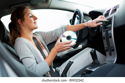 Young Female Driver Playing Music In The Car (changing CDs)