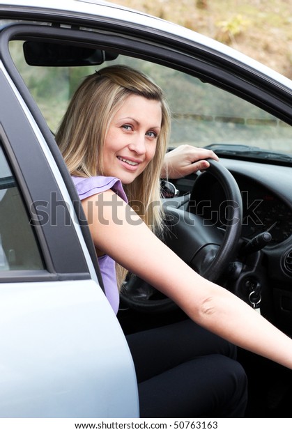 Young female\
driver at the wheel in her new\
car