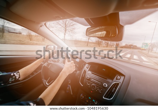 Young female driving a car. Driving a car. Sunny\
day. Modern car interior