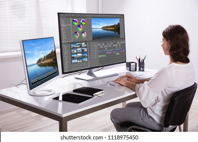 Young Female Editor Editing Video On Computer In Office