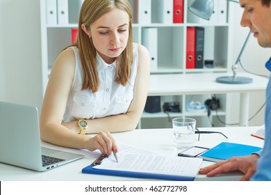 Young Female Employee Of The Staffing Agency Helps Fill Out The Form To The Male Job Seeker. Business, Office, Law And Legal Concept