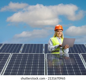 Young female engineer working on a laptop computer behind solar panels  - Shutterstock ID 2131670965