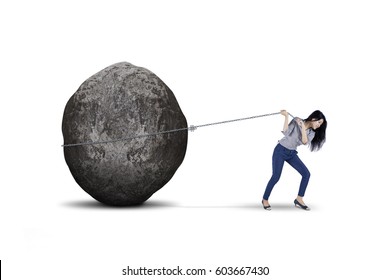 Young female entrepreneur is pulling big stone with a chain, isolated on white background