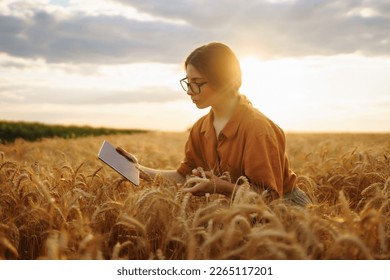 Young Female farmer with tablet in the field. Agriculture, gardening, business or ecology concept. Growth dynamics. - Powered by Shutterstock