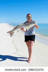 A Young Female Fisherman Shows Off The Huge Red Fish Caught While Fishing Off Pensacola Beach, Florida 