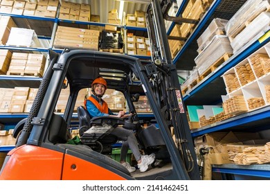 Young Female Forklift Driver Working In A Warehouse