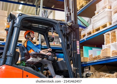 Young Female Forklift Driver Working In A Warehouse