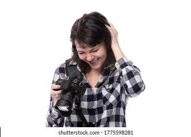 Young Female Freelance Professional Photographer Or Art Student Or Photojournalist On A White Background Holding A Camera. She Is Confused Or Shy