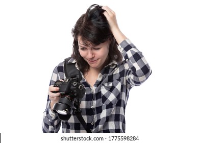 Young Female Freelance Professional Photographer Or Art Student Or Photojournalist On A White Background Holding A Camera. She Is Confused Or Shy