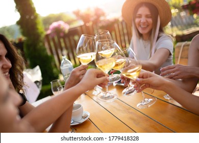 Young Female Friends Clinking Glasses With Wine On The Summer Terrace Of Cafe Or Restaurant