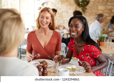 Young female friends smiling at brunch in a cafe, close up