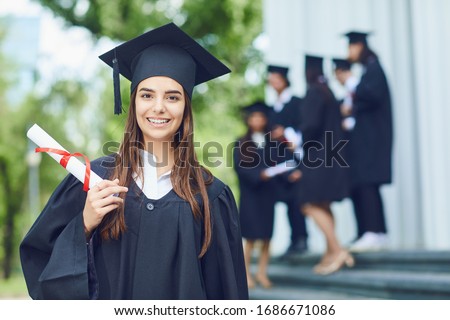 A young female graduate against the background of university graduates.