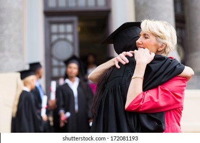 young female graduate hugging her mother at graduation ceremony