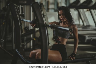 Young female in gym. Young woman in gym working out an posing. Portrait of girl in gym ready to workout. Resting after training hard. - Shutterstock ID 1318137263