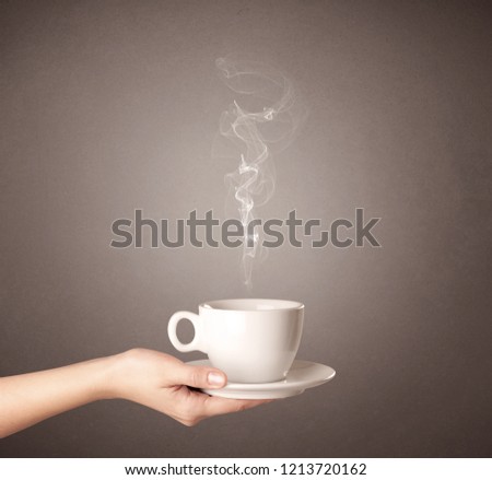 Young female hand holding steaming coffee cup 
