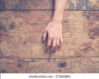 A young female hand on a wooden table - Shutterstock ID 272600801