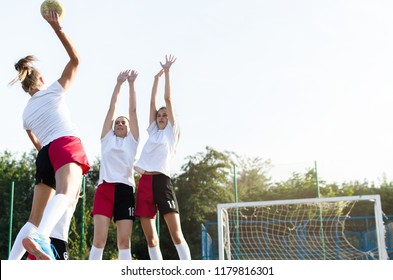 Young Female Handball Players Trying To Defent Goal During A Game. Space For Text.