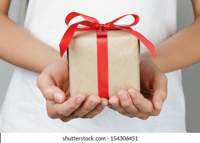 Young Female Hands Holding Gift, Red Ribbon