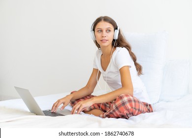 Young Female In Headphones Studying Online, Working From Home Using Laptop, Hotel Interior, Copy Space. Gig Economy, Digital Nomad,