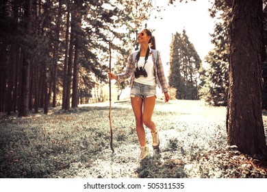 Young Female Hiking Trough Forest On Beautiful Summer Day.