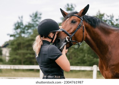 Young female horsewoman petting and bonding with her horse outside in nature - Powered by Shutterstock