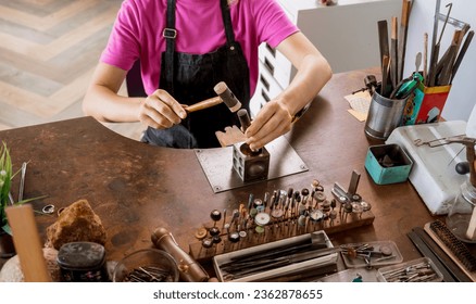 Young female jeweler making jewelry in workshop - Powered by Shutterstock