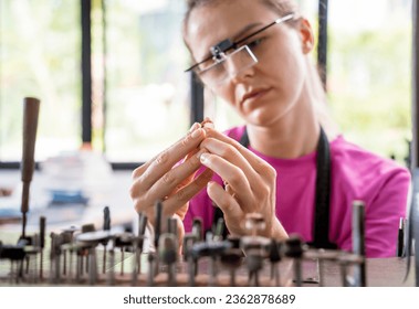 Young female jeweler making jewelry in workshop - Powered by Shutterstock