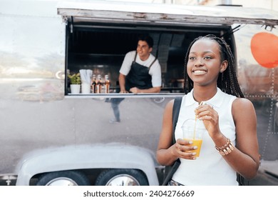 Young female with juice standing against a food truck. Girl with orange juice that she bought in a food truck. - Powered by Shutterstock