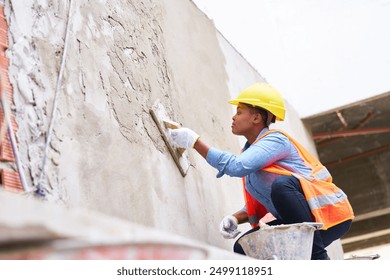 Young female labor plastering on wall with cement