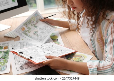 Young Female Landscape Designer Working In Office