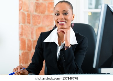 Young Female Lawyer Or Paralegal Working In Her Office On A Computer Or Pc