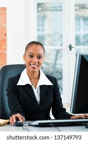 Young Female Lawyer Or Paralegal Working In Her Office On A Computer Or Pc