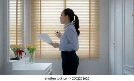 Young female leader, asia people lady or mba student happy standing smile look at in front of mirror pep talk for sale pitch hold paper document script public speak skill for job career self improve. - Shutterstock ID 2002231628