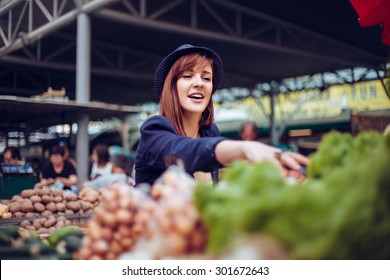 Young Female Looking For Some Vegetables At Market Place