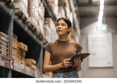 Young female manager worker checklist manage parcel box product in warehouse. Asian woman supervisor using tablet working at store industry. Logistic import export concept. - Powered by Shutterstock